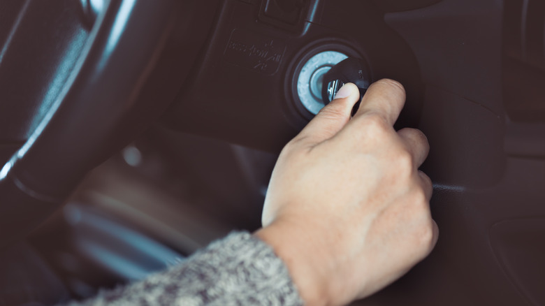 hand turning key in ignition