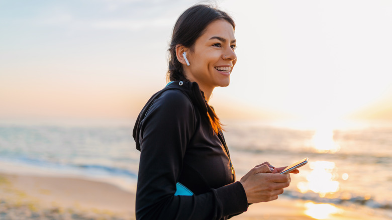 Woman wearing Airpods with phone