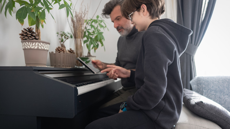 young boy and older man learning piano through app