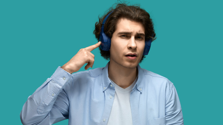 man pointing to headphones