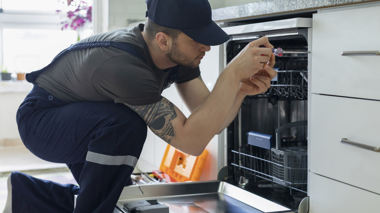 technician examining dishwasher