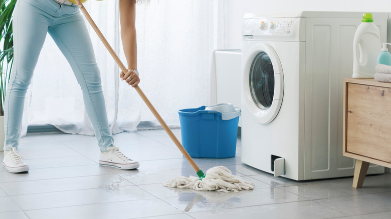 woman mopping leaked washer water