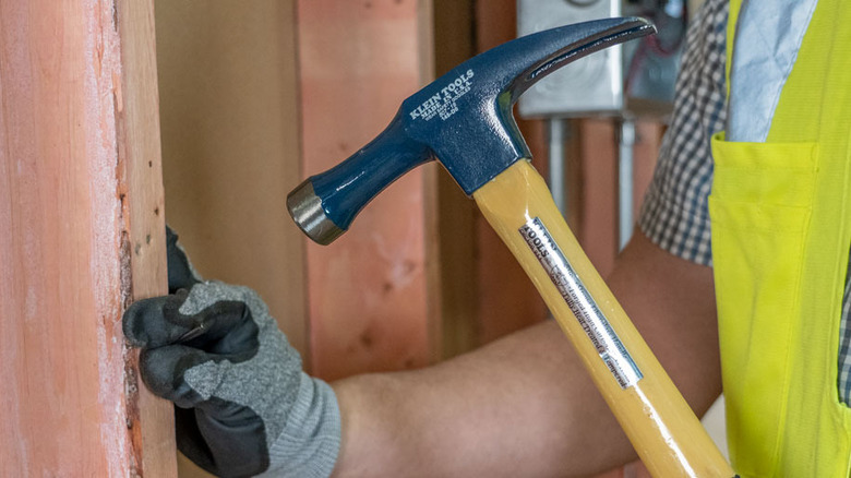 Person hammering nail into wood