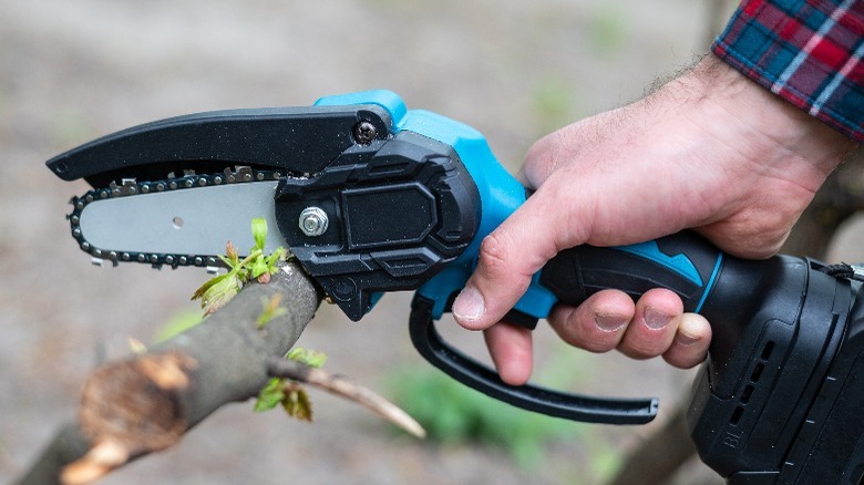 person using mini-chainsaw