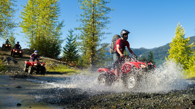 ATV enthusiasts driving through water