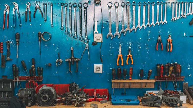 mechanics tools hanging from blue wall