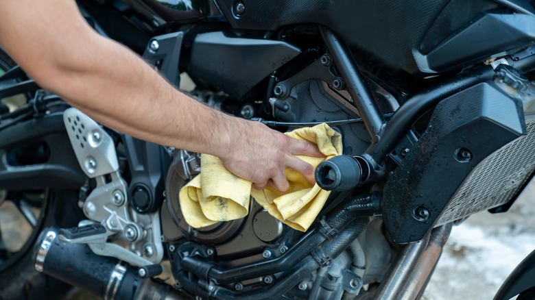 person wiping down motorcycle