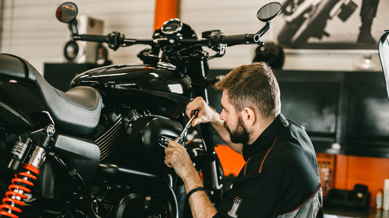 a man working on a lifted motorcycle