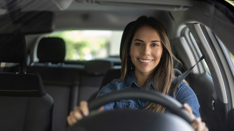 woman driving while inside car