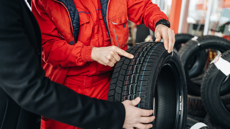 mechanics holding tires