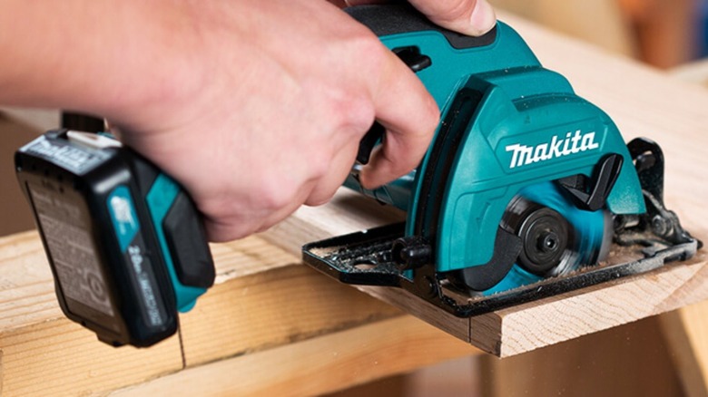 Person using a mini circular saw on thin thin