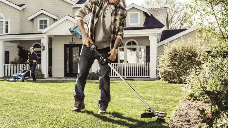 Person weed eating their front lawn