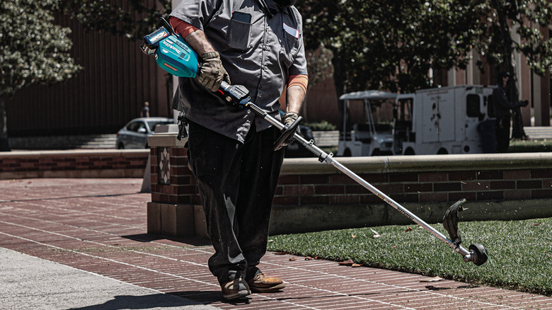 Person edging a yard with a string trimmer