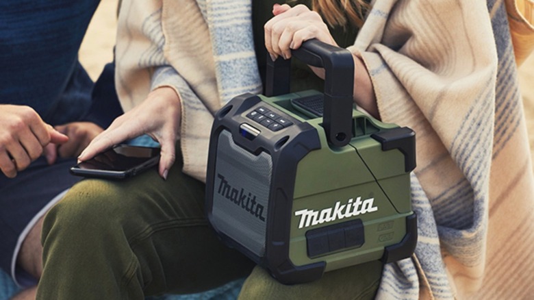 Woman holding a Makita speaker in her lap