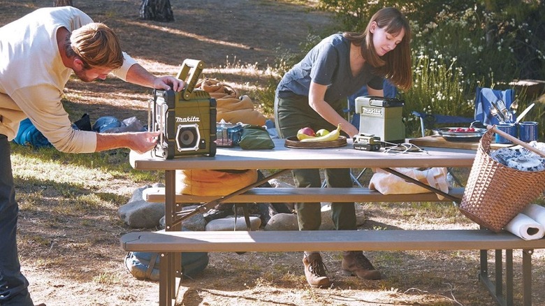 A man and a woman using Makita gear outside