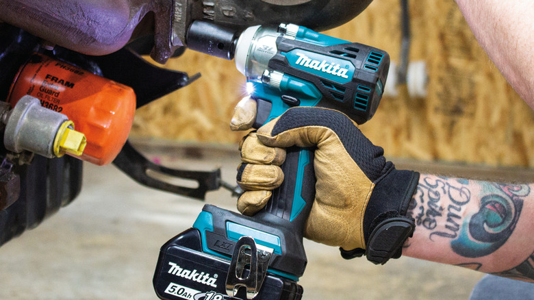 Person using an impact wrench on a car