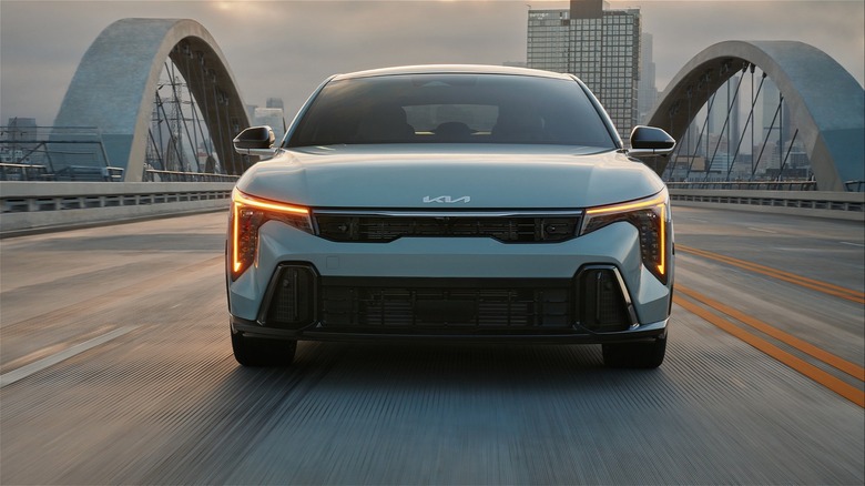 2025 Kia K4 On An Urban Bridge With A City Skyline In The Background