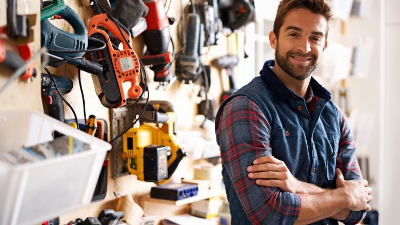 Man with tools hanging in the background