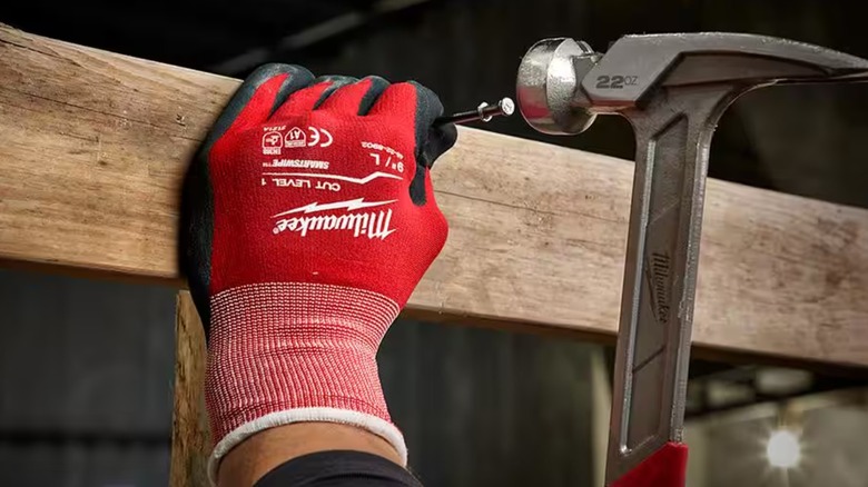 Person with a hammer wearing Milwaukee dipped work gloves