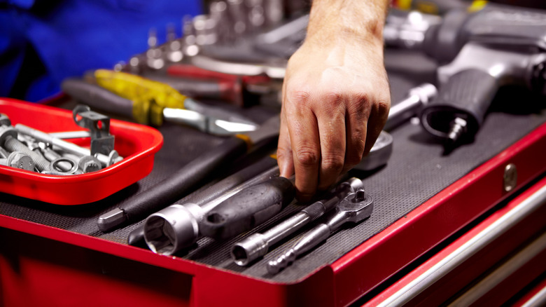 Person reaching out to a hand tool