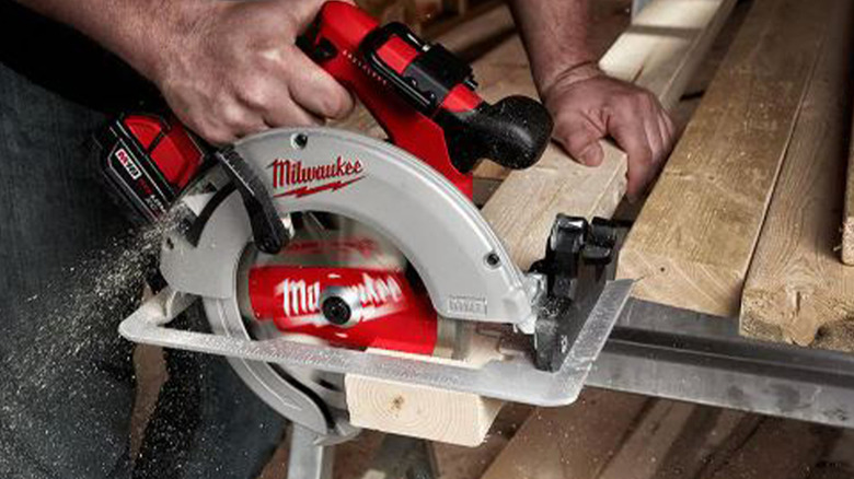 person using milwaukee saw