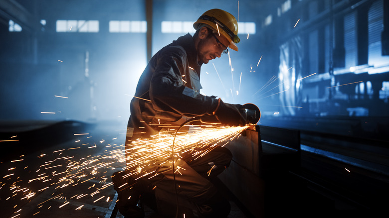 man cutting metal with tool