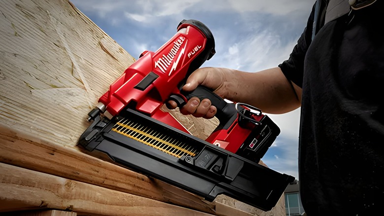 person using milwaukee nail gun