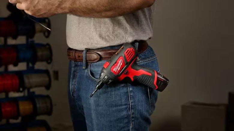 Worker with Milwaukee M12 screwdriver on belt