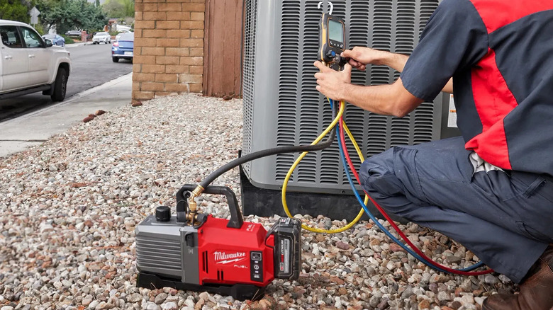 Repair person using the M18 FUEL™ 5 CFM Vacuum Pump