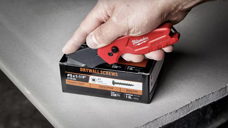 Person using a utility knife to open a box of screws