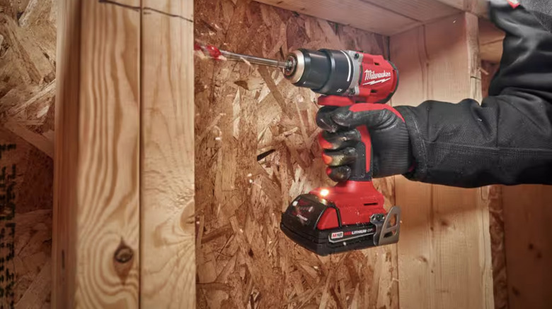 Person using a Milwaukee drill on wood 