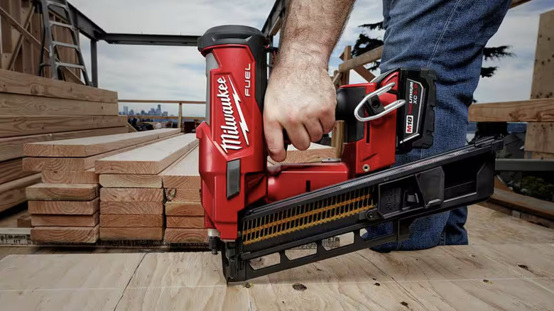 Person using nail gun on wood