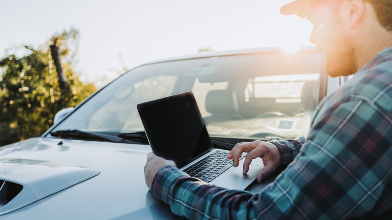 Man using laptop on truck