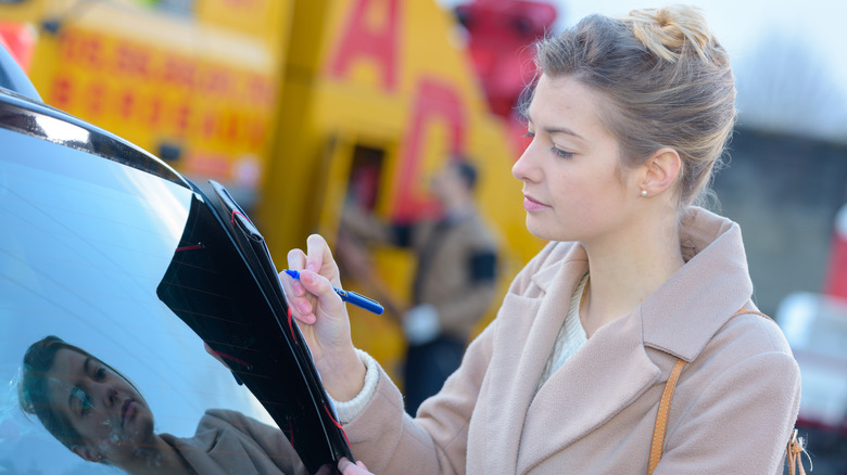 Woman checking paperwork outside truck