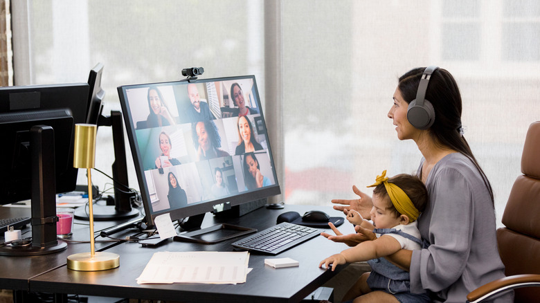 woman holding a baby while on a video conference call