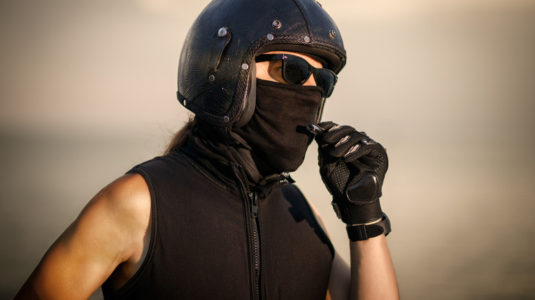 A biker wearing a cooling vest, a face covering, a helmet, and a glove