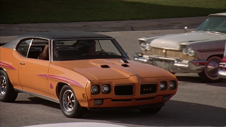 Orange GTO driving through parking lot