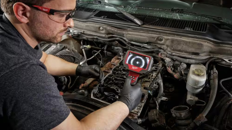 Man using borescope on car engine