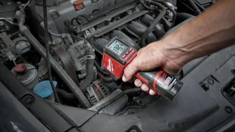 Person using heat gun on car engine