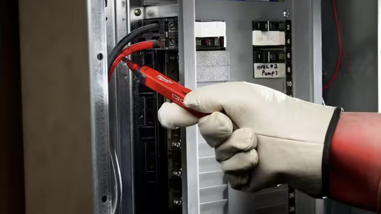 Person using voltage detector on box