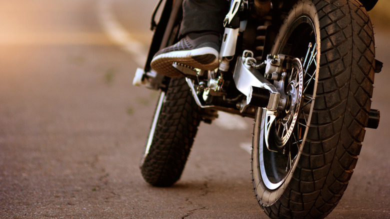 Motorcycle driving closeup rear wheel