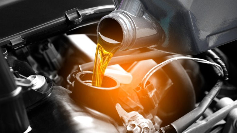 Pouring oil into car engine