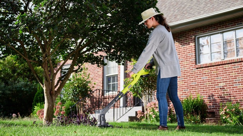 Woman using Ryobi string trimmer