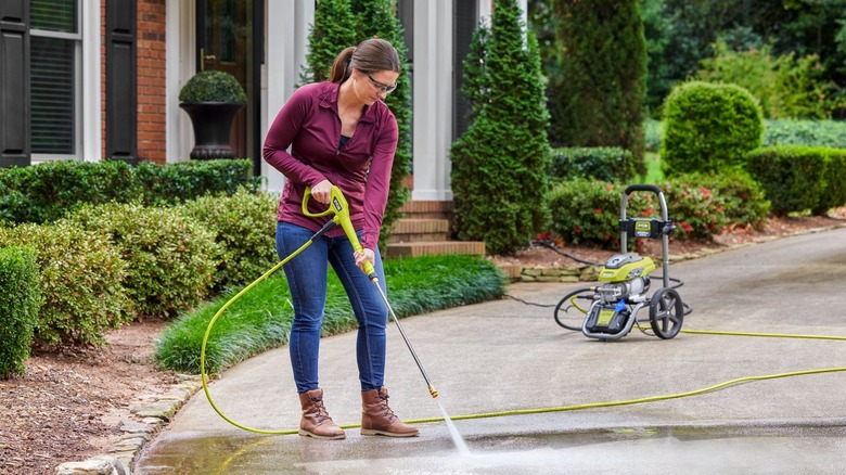 Woman using Ryobi pressure washer