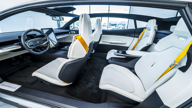 Polestar 5 concept car interior with light grey bucket seats and yellow seat belts