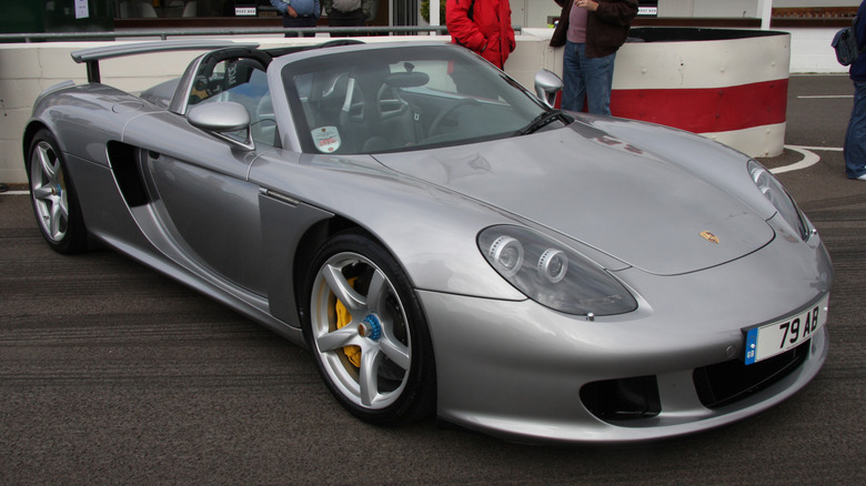 Silver Porsche Carrera GT parked on racetrack near pit lane exit