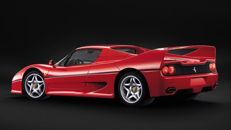 Red Ferrari F50 parked against black background