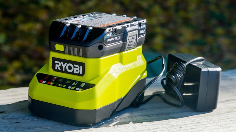 Unplugged Ryobi battery charger with battery sitting outside