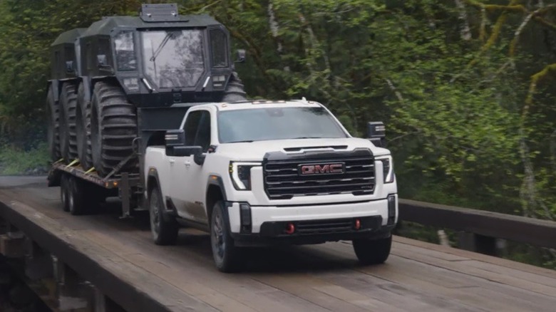 A white GMC 2500 HD towing a pair of Sherps