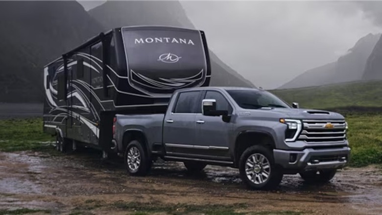 A Chevy Silverado 2500 HD towing a large Montana 5th wheel camper